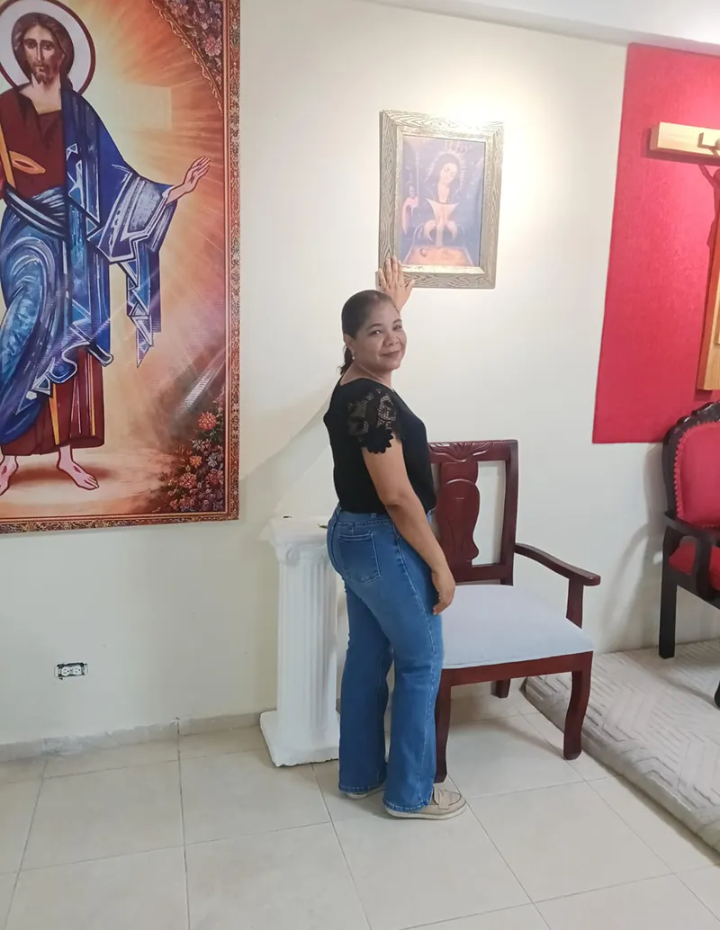 Pie de foto: Guadalupe Pérez, posando frente a una réplica del cuadro altagraciano. 